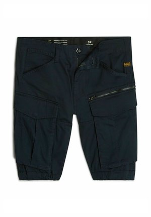 Pantaloni cargo blu navy con molte tasche, zip frontale e orlo regolabile. Realizzati in un tessuto leggero con una superficie liscia.