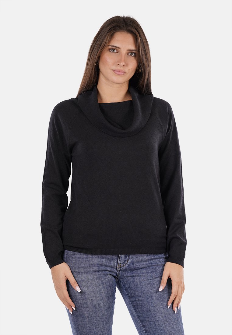 Pullover nera con colletto a scialle, maniche lunghe e vita aderente. Realizzata in un morbido tessuto testurizzato. Indossata con jeans blu.