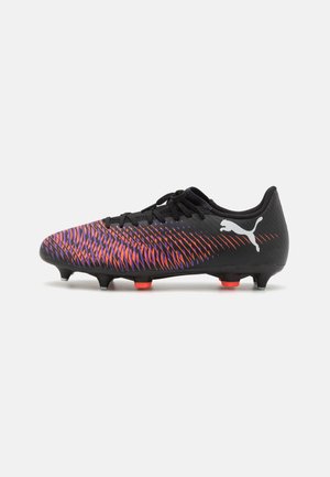 Botas de fútbol negras con una parte superior texturizada que presenta un patrón en degradado de púrpura a rojo. Incluye cordones negros y tacos rojos.