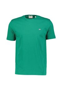 Grünes Baumwoll-T-Shirt mit kurzen Ärmeln und Rundhalsausschnitt. Verfügt über ein kleines gesticktes Logo auf der Brust. Glatte Textur, lässige Passform.