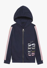 Marineblauwe zip-up hoodie met capuchon, met roze en witte gestreepte accenten op de mouwen en gedurfde, reflecterende tekst op de voorkant.