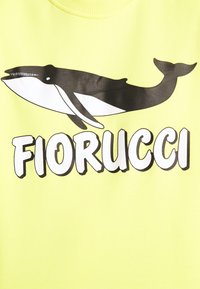 Sudadera amarilla con un gran gráfico de una ballena negra y el texto "FIORUCCI" en letras blancas en negrita, con una textura suave.