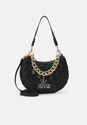 Borsa nera a mezzaluna con stelle in rilievo, catena dorata e charms a forma di stella che formano la parola "Couture", e tracolla nera regolabile.