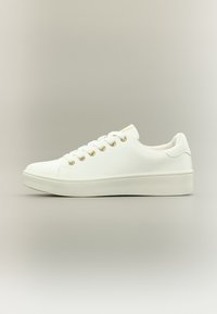 Λευκό αθλητικό παπούτσι με λείο συνθετικό επάνω μέρος, στρογγυλή μύτη, έξι χρυσά ρινίσματα και παχύ λευκό πάτο πλατφόρμας. Μινιμαλιστικός σχεδιασμός χωρίς σχέδια.