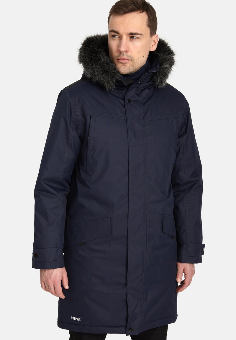 Giacca parka navy con cappuccio in pelliccia sintetica, dotata di chiusura con zip e bottoni, tasche laterali e branding discreto sull'orlo inferiore.