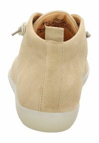 Stivale alla caviglia in suede beige con texture liscia, punta arrotondata e suola in gomma bianca. Dotato di una linguetta sul retro per indossarlo facilmente.