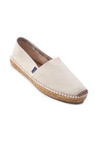 Espadrilla in tela beige con suola in juta e dettaglio di cucitura marrone sulla punta, caratterizzata da un piccolo marchio in tessuto blu navy sul lato.
