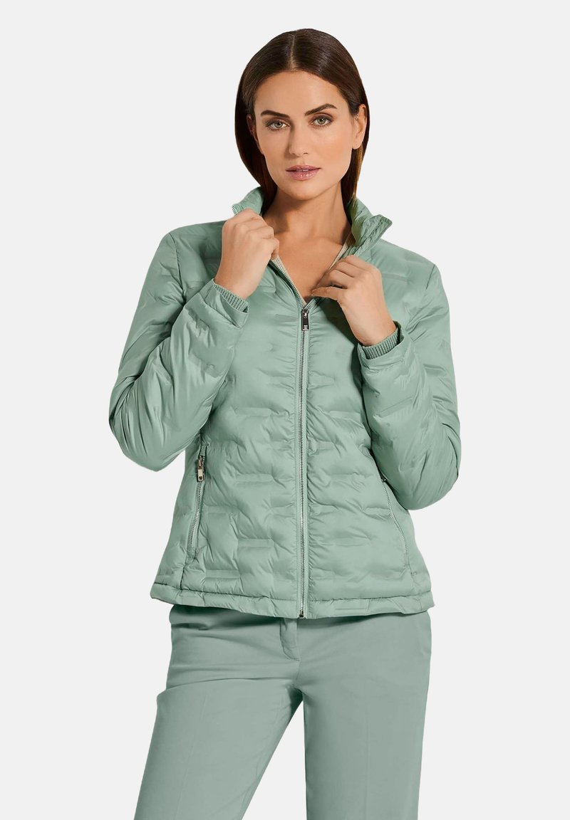 Mintgrüner, gepuffter Jacke mit Reißverschluss auf der Vorderseite, hohem Kragen und gerippten Bündchen. Mit einem gesteppten Muster und seitlichen Reißverschlusstaschen.