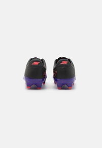 Black athletic cleats with purple soles and red accents, featuring a smooth upper texture and prominent logo on the heel.