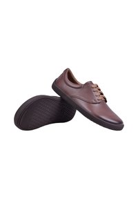 Chaussures décontractées en cuir marron à lacets avec semelles en caoutchouc foncé, une chaussure montre le dessus et l'autre le motif de la semelle.