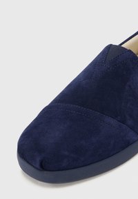 Navy plavi zamšasti cipel na slip-on s okruglim vrhom, s tonovima šavova i fleksibilnom gumenom potplatom za udobnost i lakoću nošenja.