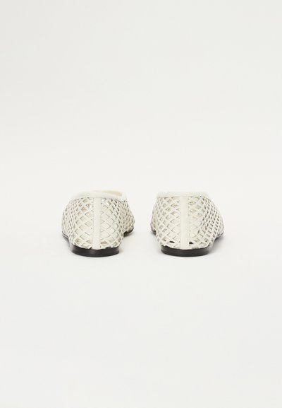 Hvide, vævede slip-on sko med et gitterdesign, der har en rund tå og sort gummisål. Glat indvendig foring.