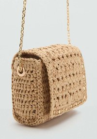 Woven straw crossbody bag in light beige, features a chain strap and rectangular shape, with a textured finish and subtle gold accents.