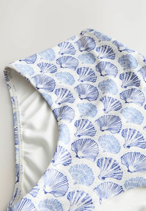 Valge ujumistrikoo alumise osa lähivõte, millel on siniseid merekarpe kujutav muster sileda kangapõhja peal.