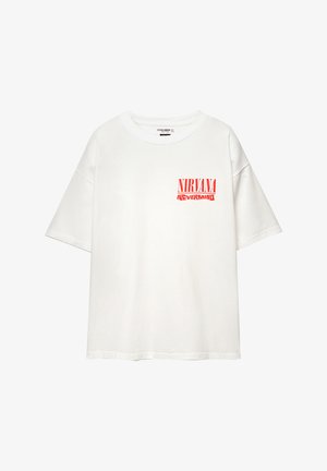 T-shirt en coton blanc à manches courtes, avec le texte rouge "NIRVANA" et "NEVERMIND" sur la poitrine gauche. Coupe relaxée et encolure ronde.
