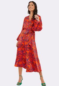Langes, florales Kleid in lebendigen Rot-, Orange- und Blautönen. Mit V-Ausschnitt, durchgehender Knopfleiste, langen Puffärmeln und einem gebundenen Gürtel-Detail.