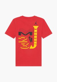 Červené bavlněné tričko s černým a žlutým grafickým textem a designy na zadní straně, včetně "Jordan" a siluety loga.