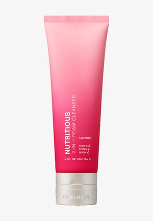 Lyserød gradient plastikrør med sølvbund, mærket "Nærende 2-i-1 Skumrens" i hvid. Kapacitet: 4,2 fl. oz. (125 mL).