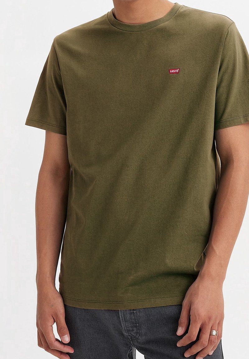 T-shirt à manches courtes vert olive en coton doux. Présente un petit logo Levi's rouge sur la poitrine et un design classique à col rond.