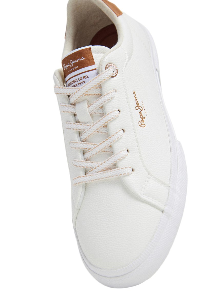 Białe sneakersy z teksturowaną skórzaną cholewką, beżowymi sznurowadłami i brązowym skórzanym akcentem na pięcie. Posiadają logo marki oraz elementy retro w designie.