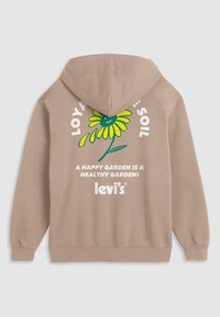 Bruine hoodie met een kleurrijk bloemenontwerp en de tekst "LOVING SOIL" in witte letters, met daaronder "EEN VREUGDIGE TUIN IS EEN GEZONDE TUIN!"
