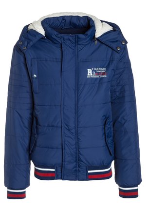 Veste matelassée bleu marine avec capuche doublée en polaire blanche, fermeture éclair à l'avant, logo poitrine et poignets et ourlet côtelés rayés rouge, blanc et bleu.