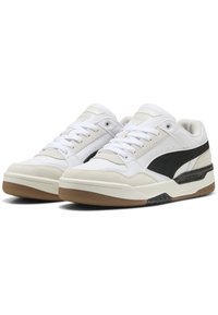 Hvide sneakers med sorte accenter, lavet af læder og ruskind, med en struktureret gummisål og standard snørebånd. Minimalistisk design.