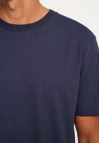 Navy blue cotton t-shirt with a round neckline and short sleeves, featuring a smooth texture and minimal stitching details.