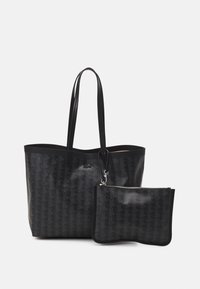 Sac fourre-tout noir en matériau texturé, comportant un motif imprimé, deux longues poignées et une petite pochette zippée attachée à l'intérieur.