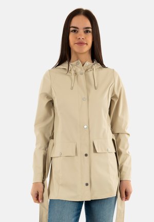 Chaqueta impermeable beige con capucha, botones a presión y bolsillos frontales. Textura suave con cordones ajustables y un corte holgado.