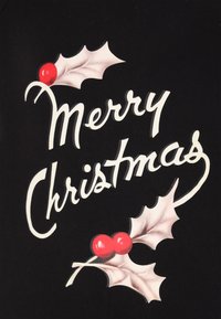 Tessuto nero con testo bianco "Buon Natale" circondato da foglie di agrifoglio e bacche rosse. Tessitura morbida, lettere ben evidenti e immagini festive.