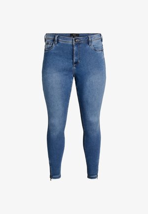 Niebieskie dżinsy skinny z wysokim stanem, przednimi kieszeniami i suwakiem przy kostkach. Lekko sprana faktura materiału.