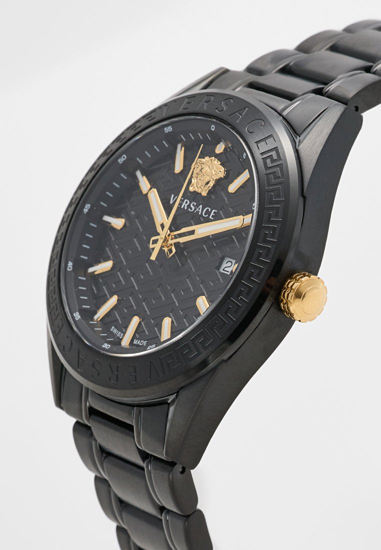 Schwarze Edelstahl-Uhr mit einem gemusterten, schwarzen Zifferblatt, goldenen Akzenten und einem runden Gehäuse. Verfügt über eine goldene Krone und Stundenmarkierungen.