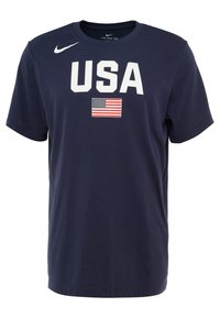 Laivastonsininen lyhythihainen puuvillainen t-paita, jossa valkoinen "USA"-teksti ja sen alla pieni Yhdysvaltain lippu, Nike-logo vasemmassa olkapäässä.
