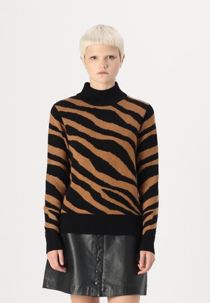 Pull à col roulé rayé marron et noir avec des poignets et un ourlet côtelés, associé à une jupe en cuir noir avec des détails de boutons.
