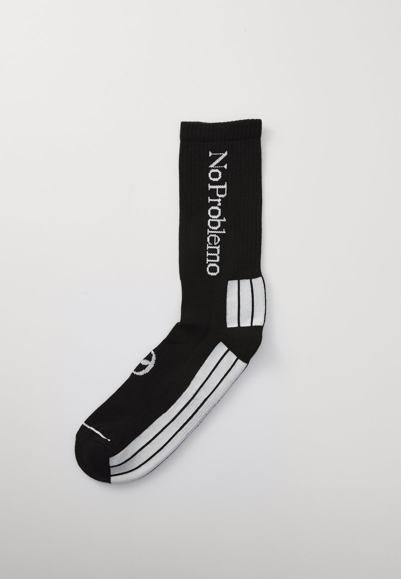 Schwarze Stricksocke mit weißer Aufschrift "No Problemo" und Streifen. Verfügt über gerippte Textur und eine abgerundete Spitze.