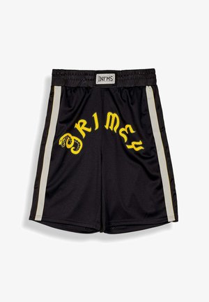 Pantalones cortos deportivos negros con rayas laterales blancas, texto estilizado "PRIMELY" en amarillo y un gráfico de serpiente en la parte delantera, cintura elástica con etiqueta "INFMS".