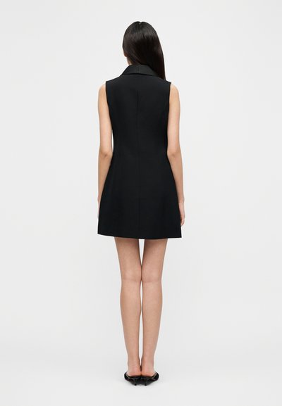 Fekete ujjatlan ruha gallérral, testhezálló felsőrésszel és bővülő szoknyával. Simább anyag, minimalista kialakítás, térd fölötti hosszúság.