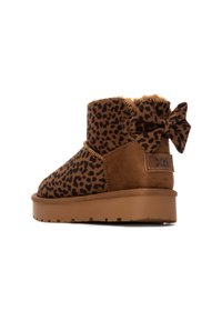 Botines de tobillo con estampado de leopardo marrón, forrados con suave pelo, con un lazo decorativo en la parte posterior y una suela de goma resistente.