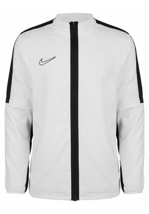 Veste blanche Nike avec fermeture éclair noire et bandes noires le long de chaque manche, arborant le logo swoosh de Nike sur le côté gauche de la poitrine.