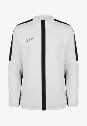 Veste blanche Nike avec fermeture éclair noire et bandes noires le long de chaque manche, arborant le logo swoosh de Nike sur le côté gauche de la poitrine.