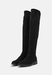 Botas de ante negras hasta la rodilla con una textura suave y suela de goma plana. Presentan un diseño sin costuras y puntera redonda para mayor comodidad.
