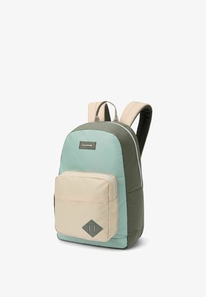 Sac à dos avec des bretelles beiges rembourrées, poche zippée à l'avant beige et corps principal en vert et bleu clair, logo Dakine à l'avant.