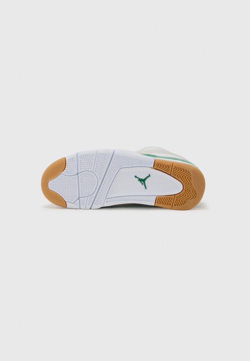 Semelle de chaussure de sport blanche avec un motif en zigzag, dotée d'un logo à accents verts et d'une section en caoutchouc beige au talon pour une meilleure traction.