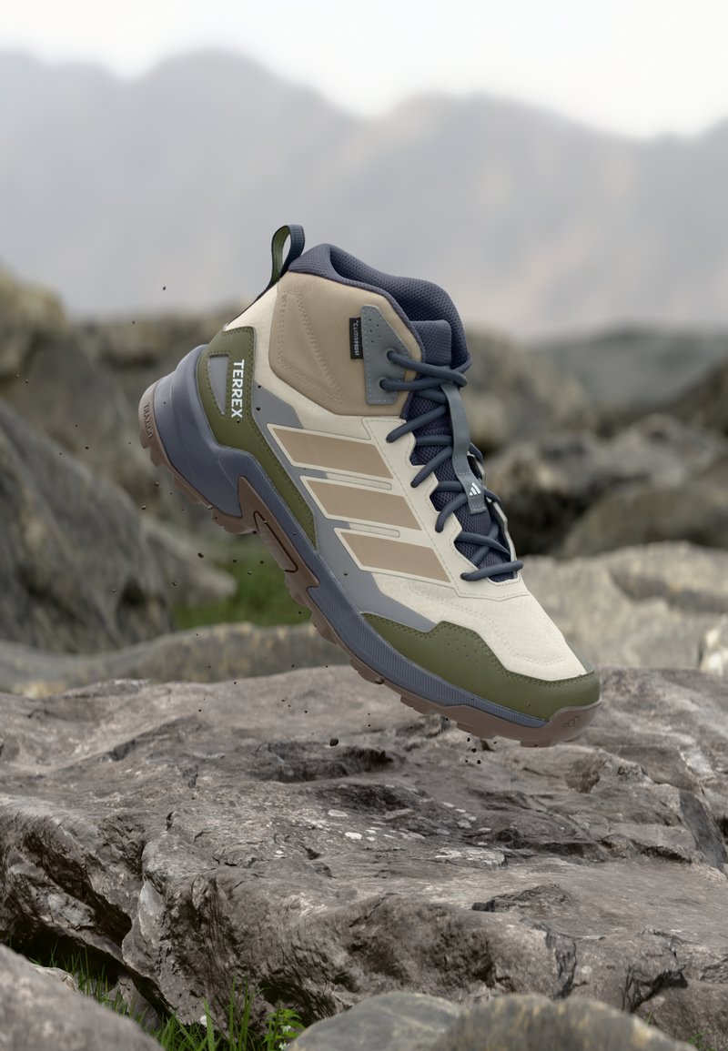 Wanderschuh mit hohem Schaft in Beige und Olivgrün, mit strukturiertem Stoff, grauen Akzenten und einer Gummisohle für besseren Halt.