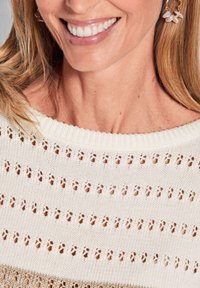 Gebreide sweater met opengewerkt patroon in crème, met een ribbelkraag. Licht, textuurstof met een modern ontwerp.