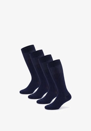 Vier Paare dunkelblaue gerippte Kniesocken, in einer versetzten Linie auf weißem Hintergrund angeordnet.