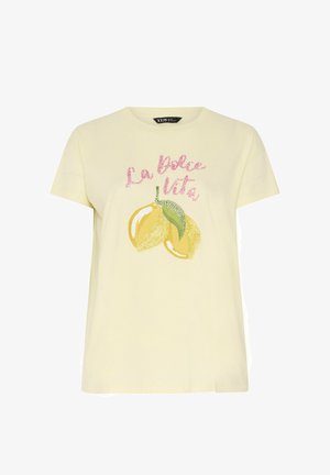 Lysegul T-shirt med korte ærmer, lyserød tekst "La dolce vita" og to illustrerede gule citroner med grønne blade på forsiden.