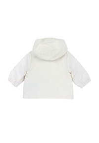 Veste à capuche blanche avec des manches longues, des poignets élastiques et un tissu texturé. Design simple, sans embellissements ni motifs visibles.