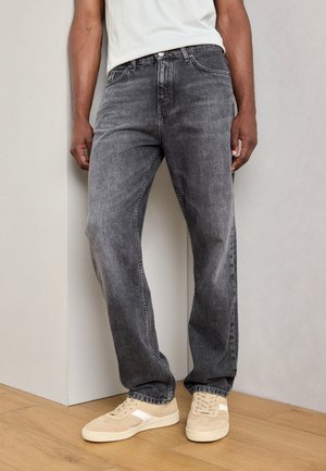 Gray denim jeans with a loose fit, slight distressing, and classic five-pocket design, paired with light beige sneakers.